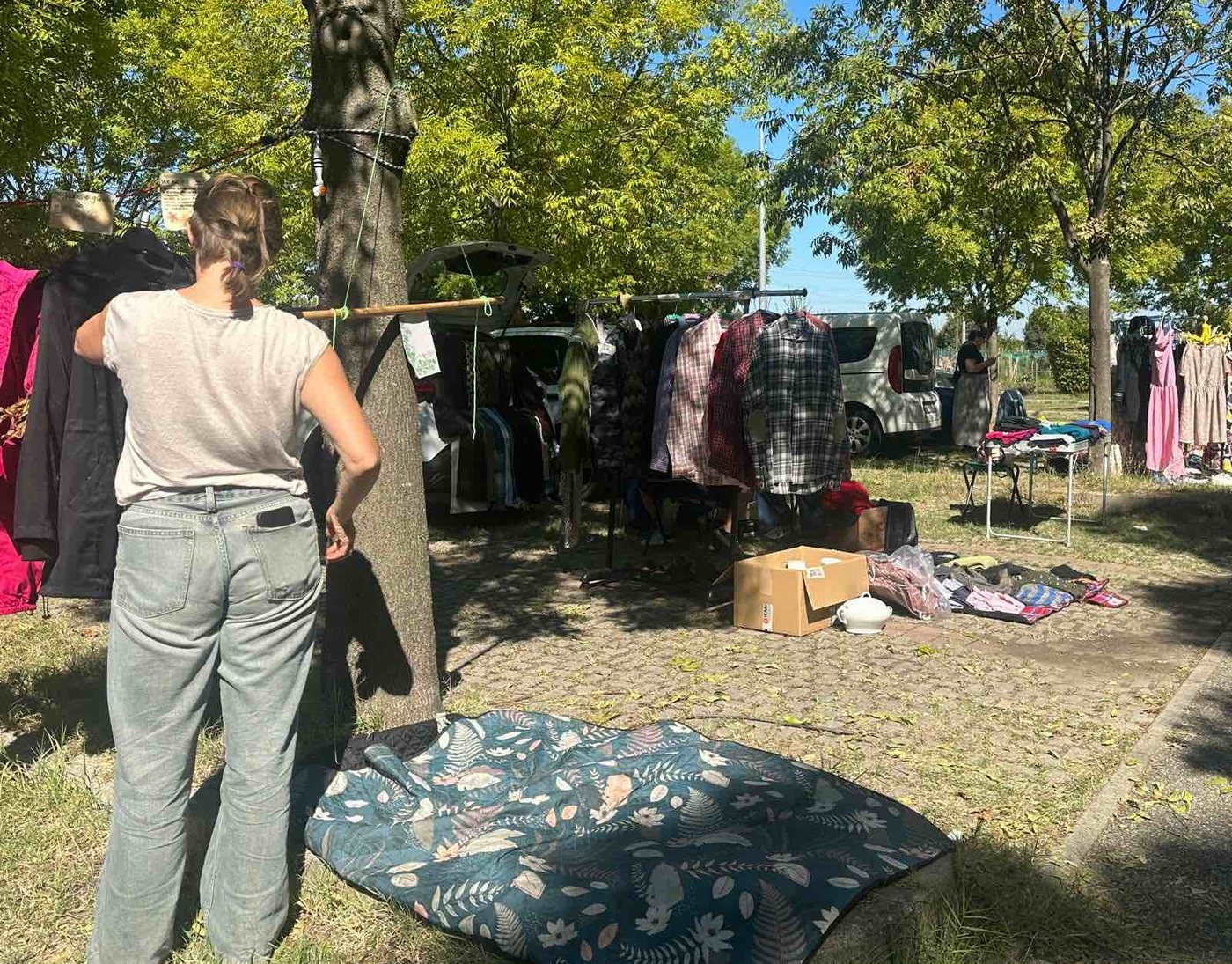 Una volontaria stende un telo sull'erba